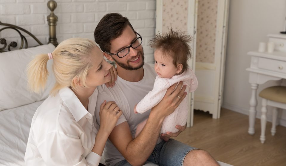 Fiatal pár fogja a gyerekét