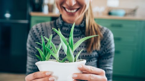 aloe verát fog a nő és mosolyog