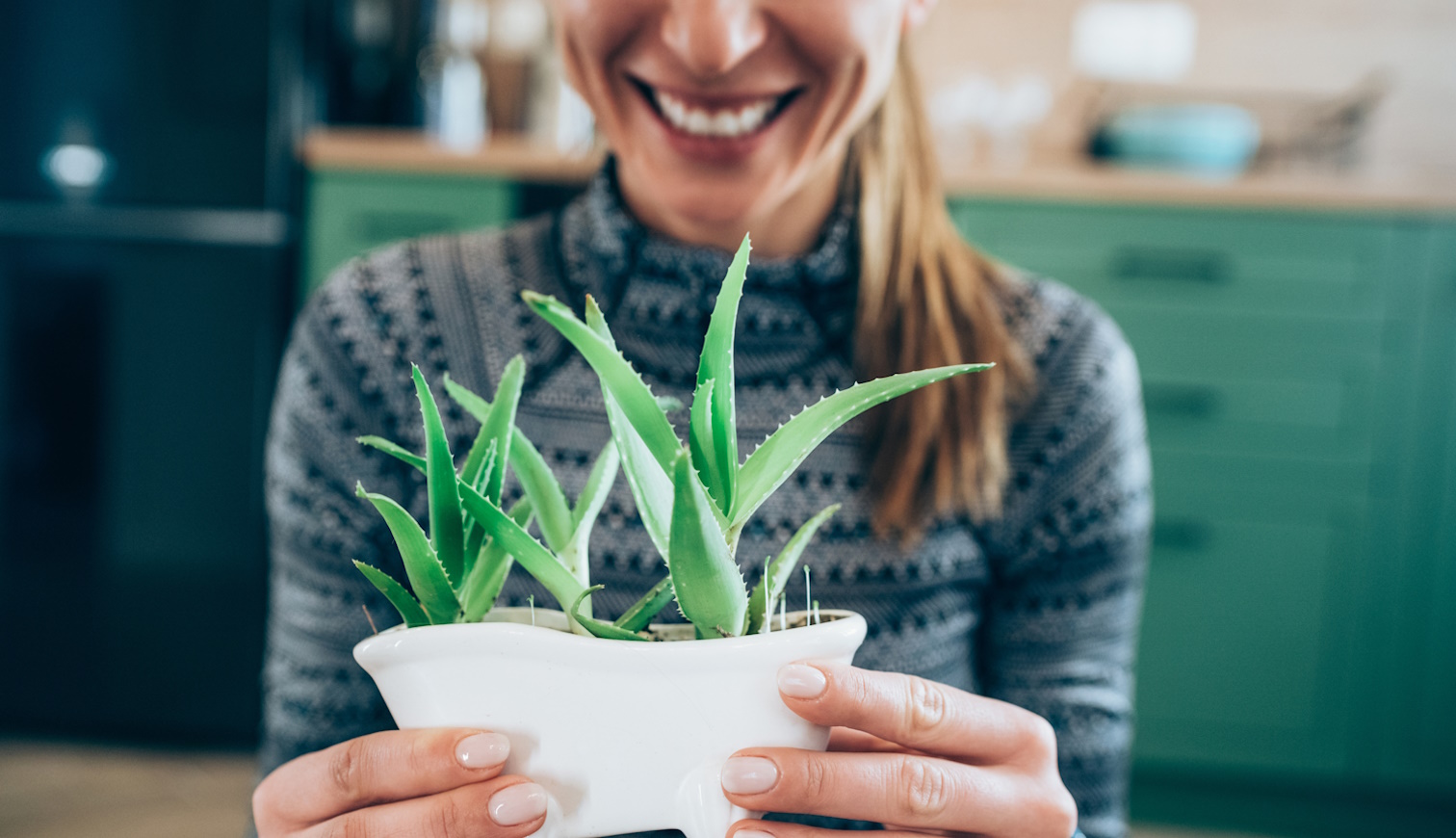 aloe verát fog a nő és mosolyog