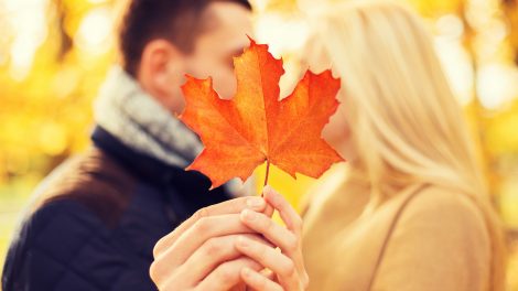 Egy nő és egy férfi csókolózik egy falevelet maguk elé tartva