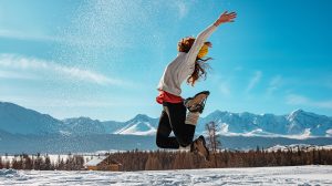 Boldog lány ugrik a hóban