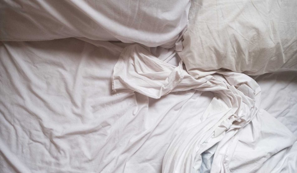 fehér ágy fehér ágyneművel gyűrötten