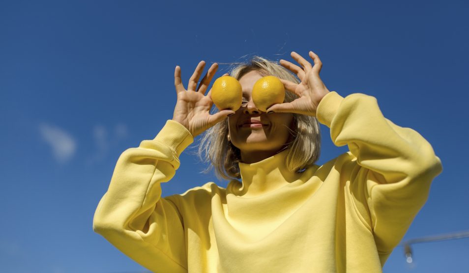 Egy nő citromot tart a szeme elé