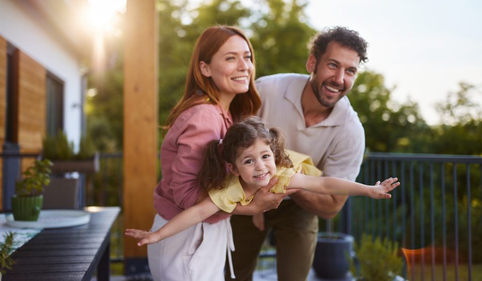 Egy pár játszik a kislányukkal