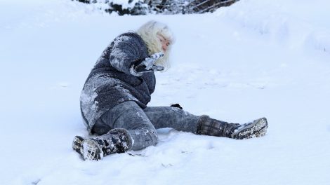 idős hölgy elcsúszik a hóban a járdán