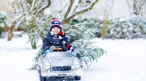 fehér karácsonynak örül a kisfiú a hóesésben az udvaron