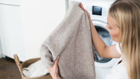 gyapjú pulóvert most egy fiatal nő mosógépben