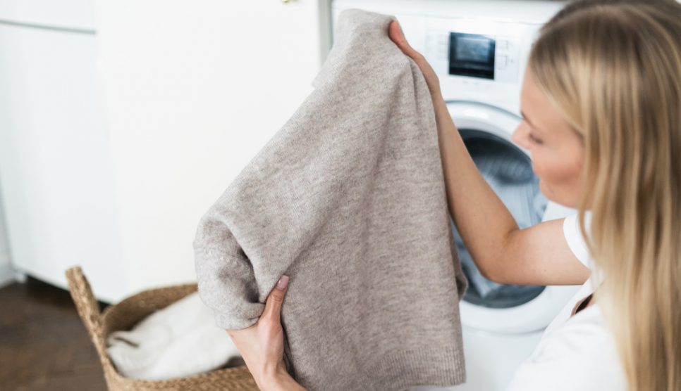 gyapjú pulóvert most egy fiatal nő mosógépben
