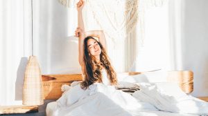 Hálószobában nyújtózkodik egy lány