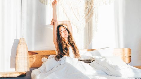 Hálószobában nyújtózkodik egy lány