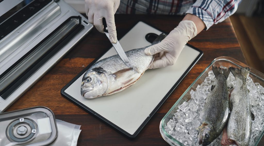 nő pontyot pucol a lakásban