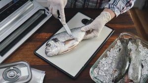 nő pontyot pucol a lakásban