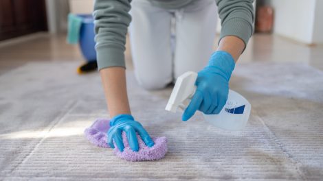 házi szőnyegtisztitó keveréket fúj a koszos szőnyegre egy nő