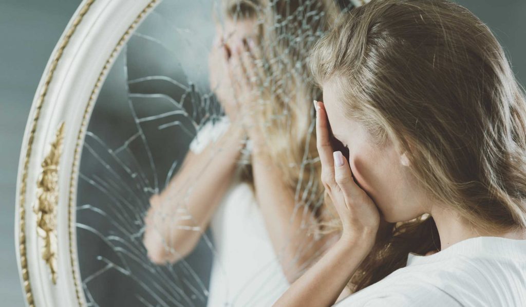 nő széttöri a tükröt