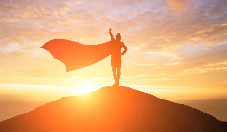 nő áll a dombon palásttal szuperhősként