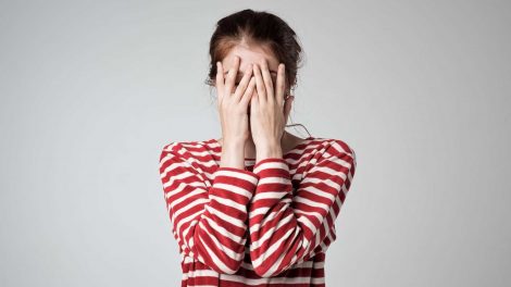 nő eltakarja az arcát