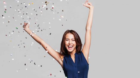 nő konfettivel szürke háttér előtt