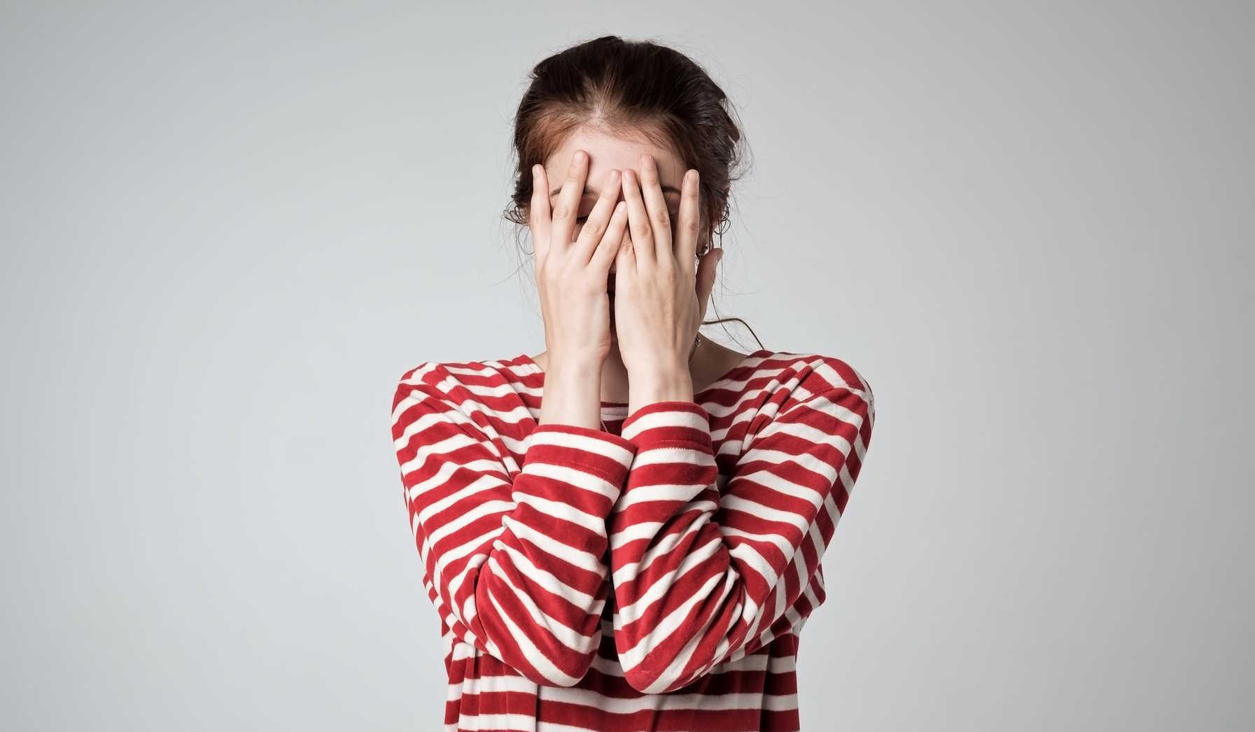 nő eltakarja az arcát