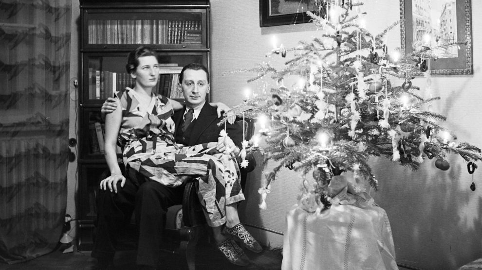 régi ronda karácsonyfa előtt ül a házaspár