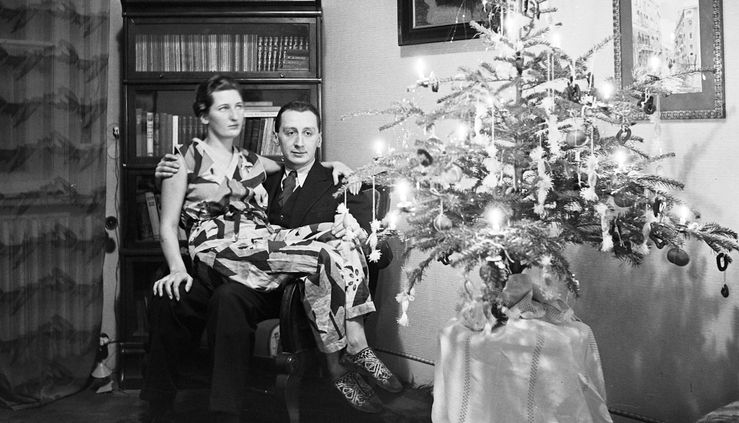 régi ronda karácsonyfa előtt ül a házaspár