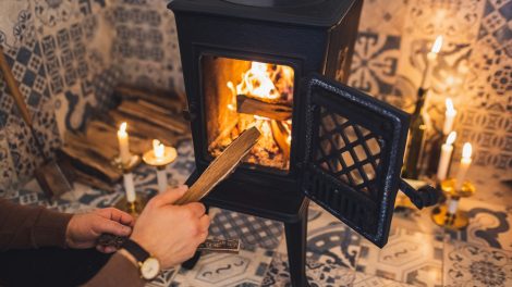 férfi gyújt be a kályhába nedves fával