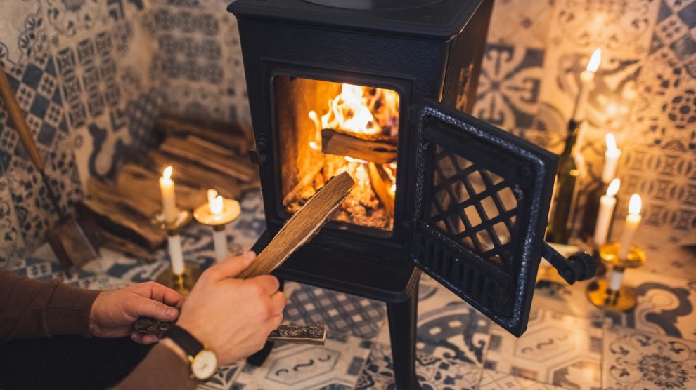 férfi gyújt be a kályhába nedves fával