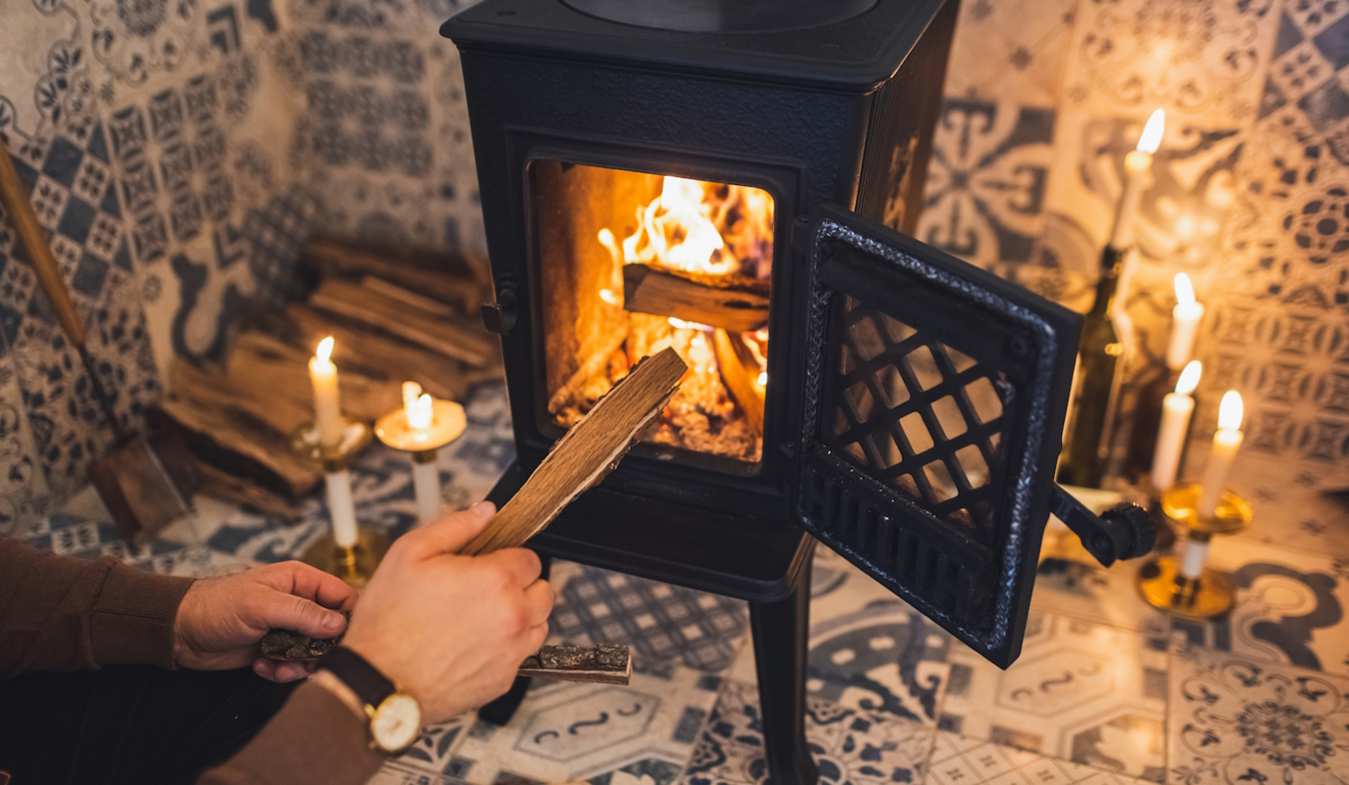 férfi gyújt be a kályhába nedves fával