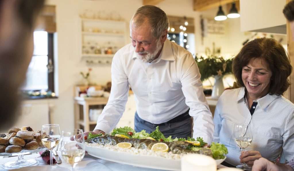 karácsonyra halat tálal a családnak egy férfi
