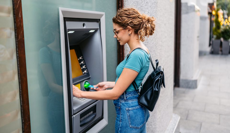 Egy nő bankkáryta automatat használ