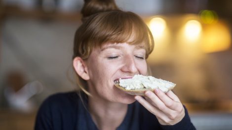 Egy nő vajas kenyeret eszik