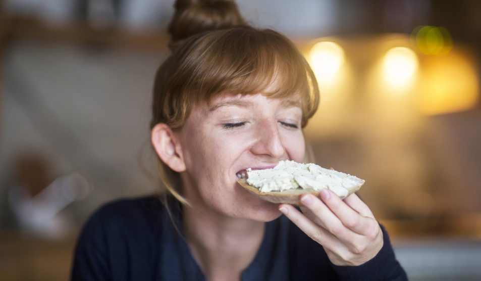 Egy nő vajas kenyeret eszik