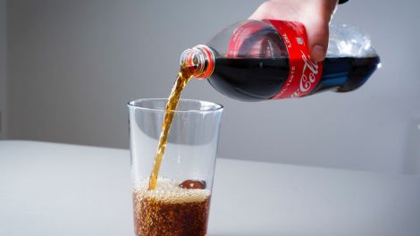 kólát tölt pohárba egy férfi