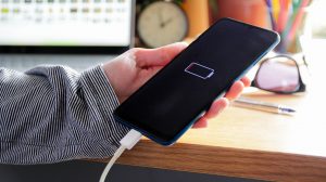 mobiltelefont tölt egy nő