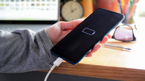 mobiltelefont tölt egy nő