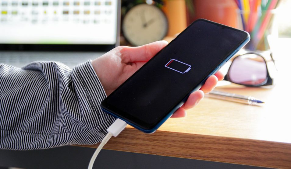 mobiltelefont tölt egy nő