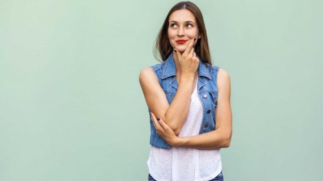 nő piros rúzzsal pózol a fal előtt