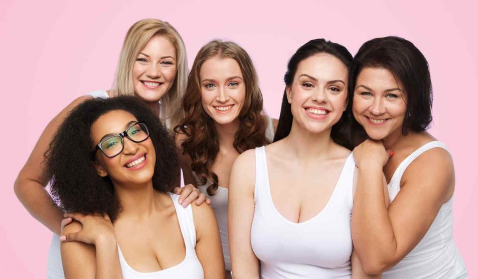 5 nő mosolyog rózsaszín háttér előtt