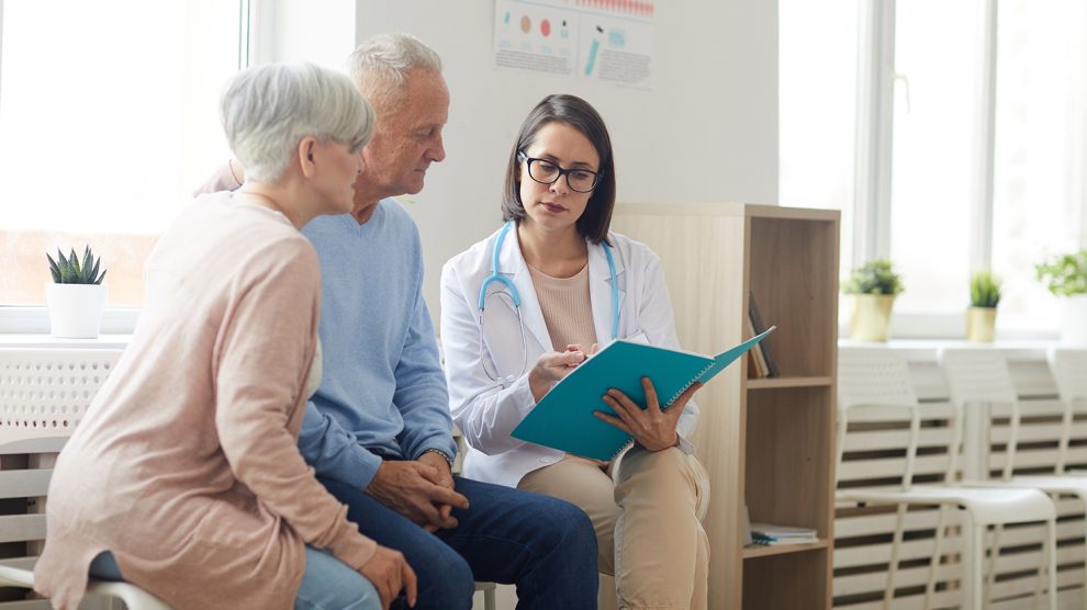 Fiatal orvosnő mutatja egy idős párnak az eredményeket