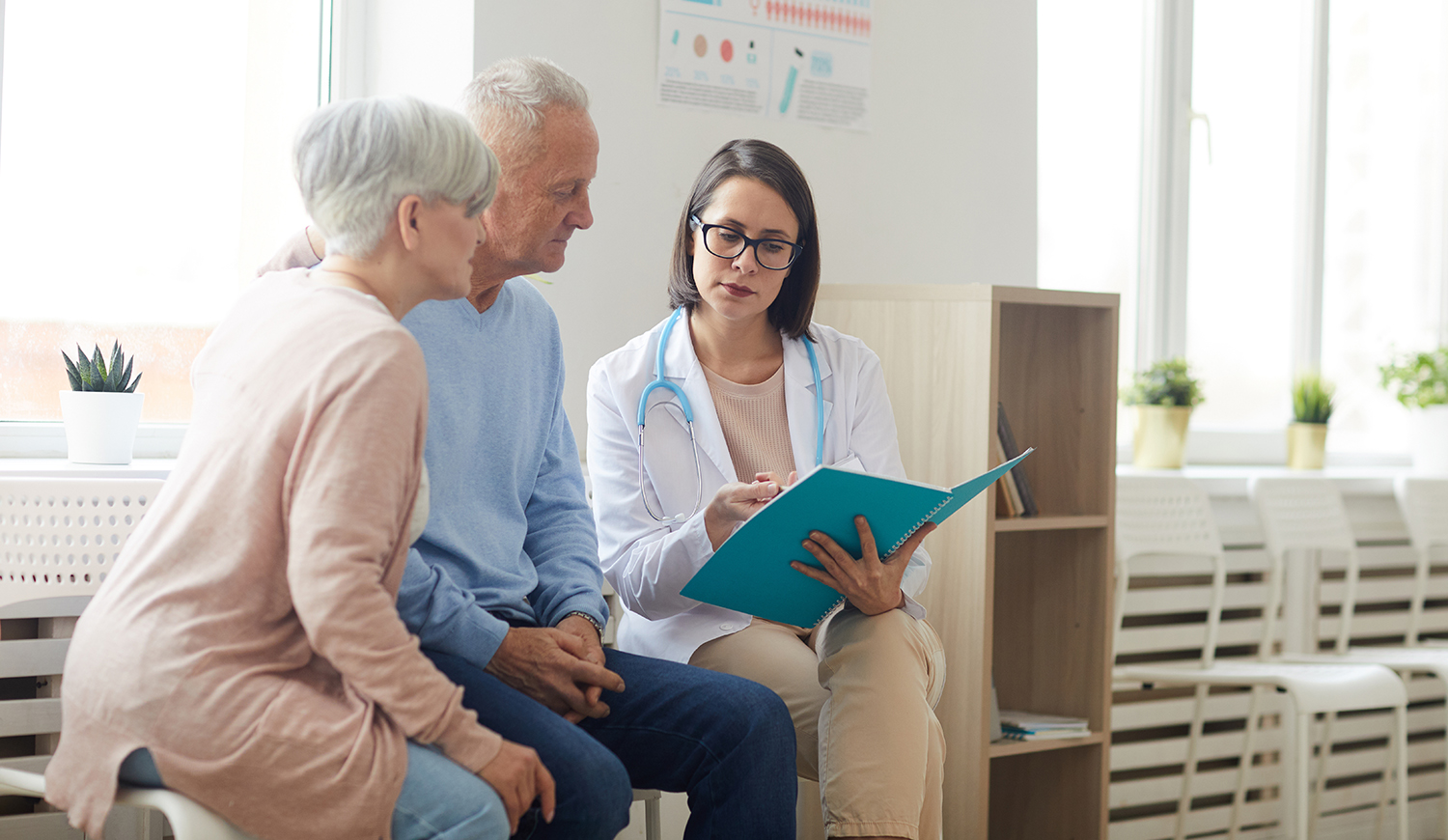 Fiatal orvosnő mutatja egy idős párnak az eredményeket
