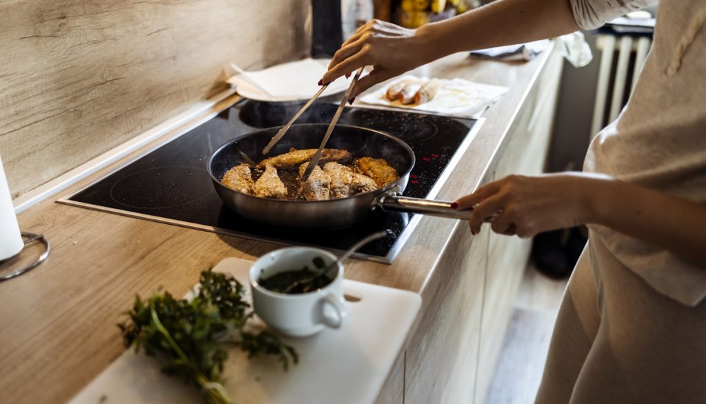 rántott halat süt egy nő olajban karácsonyra