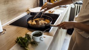 rántott halat süt egy nő olajban karácsonyra