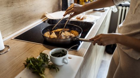 rántott halat süt egy nő olajban karácsonyra