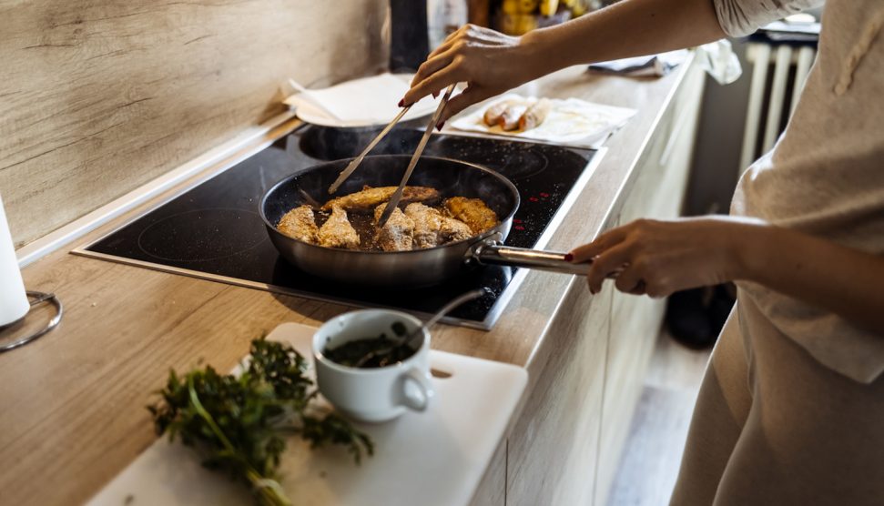 rántott halat süt egy nő olajban karácsonyra