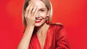 Piros ruhás középkorú nő alkali sminkben