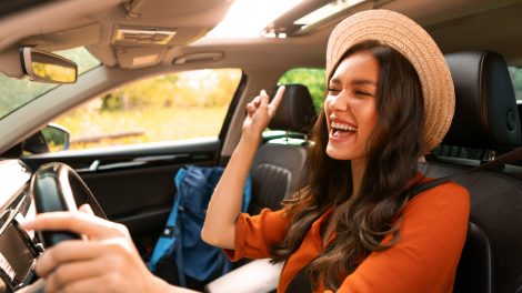 szerencsés nő örül vezetés közben a 2026-os horoszkópjának