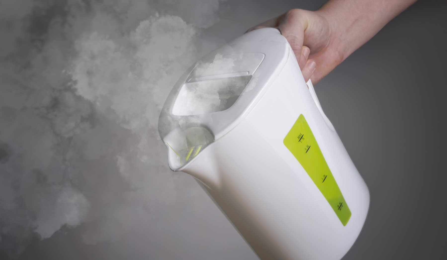 vízforralóból önti ki a forró vizet