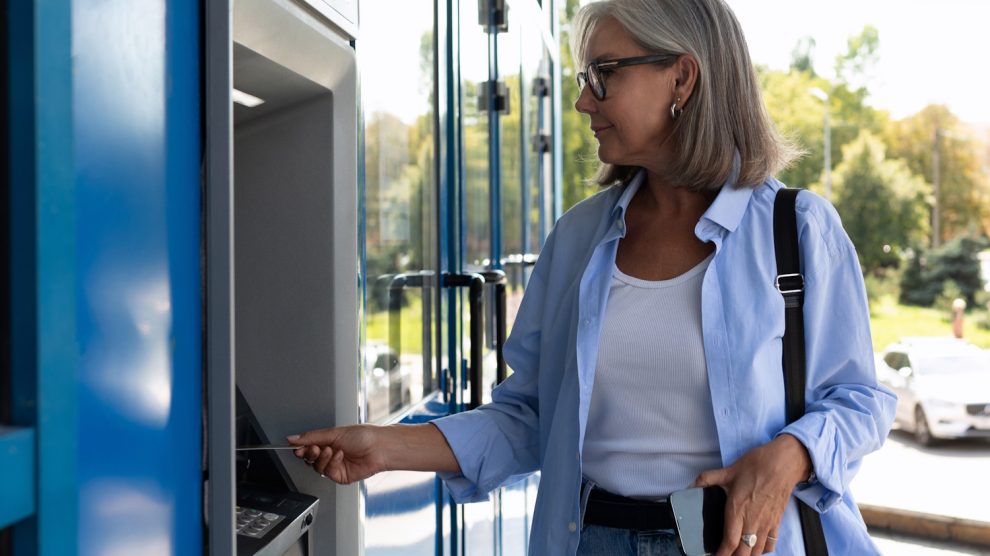 atm bankautomatából pénzt vesz fel egy idősebb nő