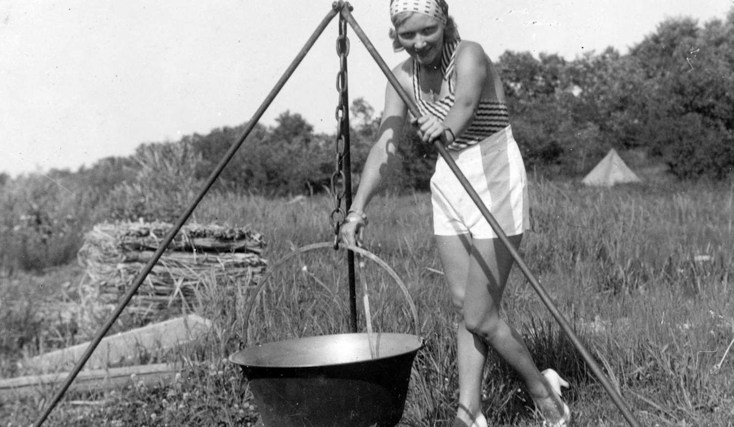 Egy lány főz a szabadban bográcsban