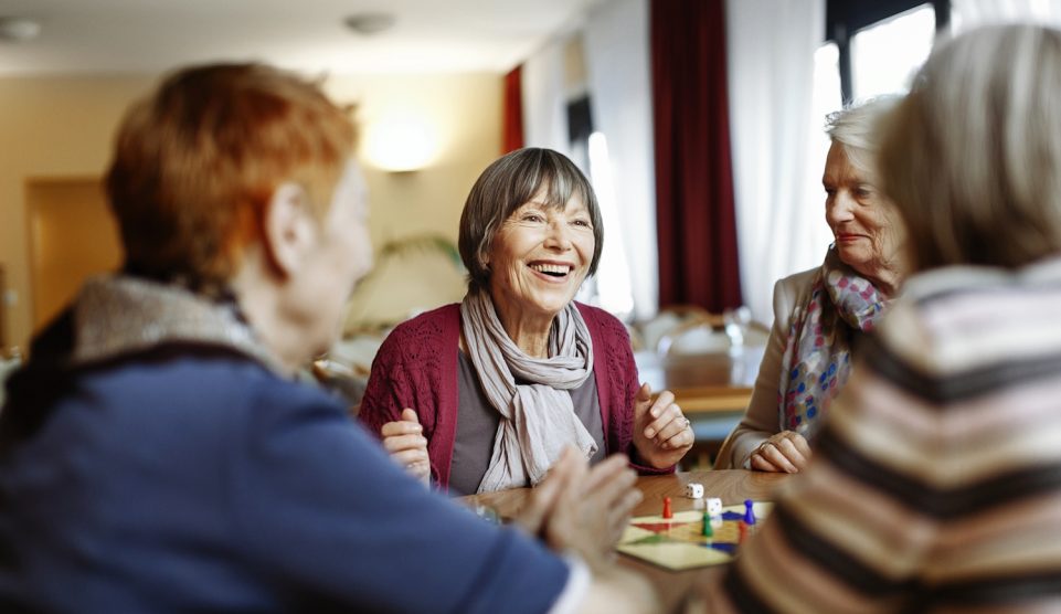 Egy idős társaság nevetgél egy asztal körül
