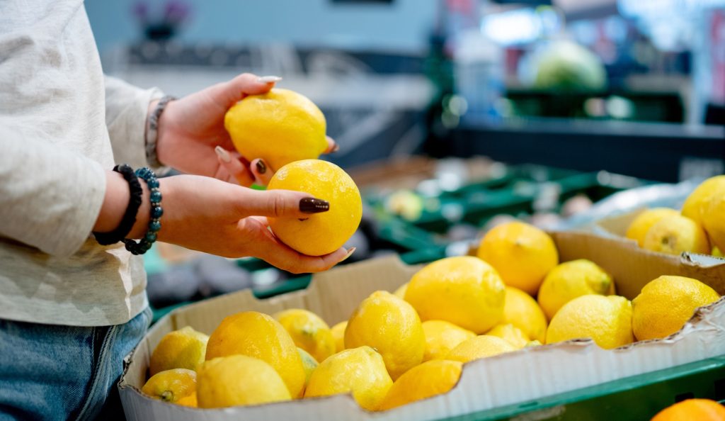 nő citromot válogat a boltban